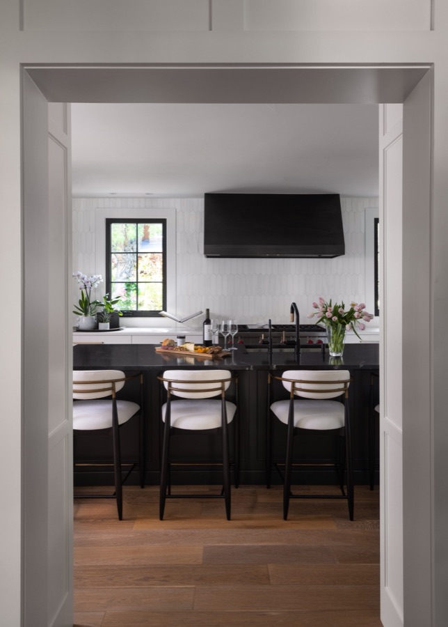 Butler's pantry with black cabinetry and white oak floors seen through a cased opening — Greenwood Village hidden-detail whole home renovation