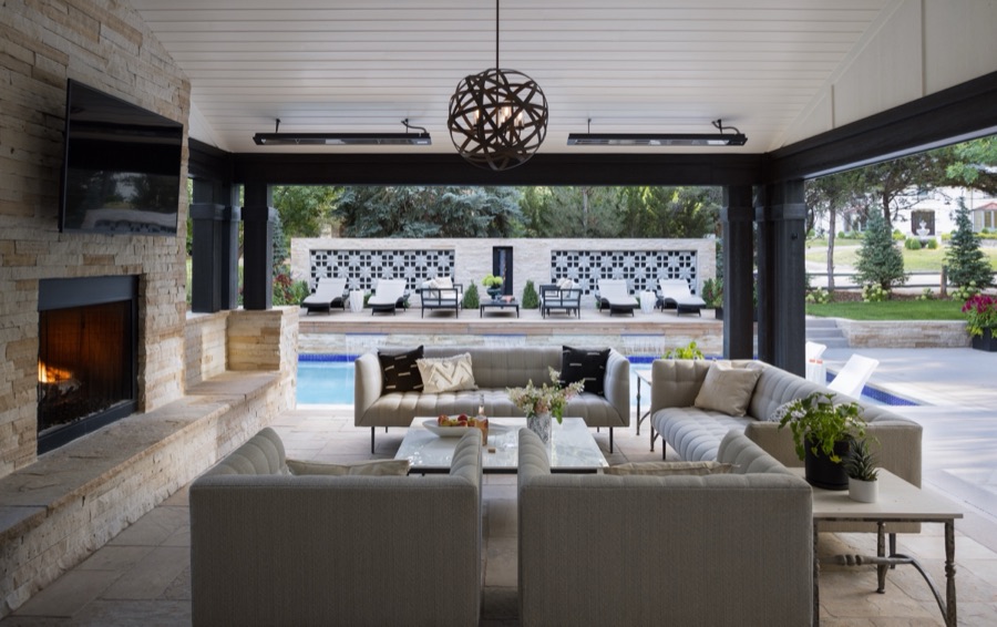 Covered outdoor living room with fireplace, sectional, and view to the pool — Greenwood Village hidden-detail whole home renovation