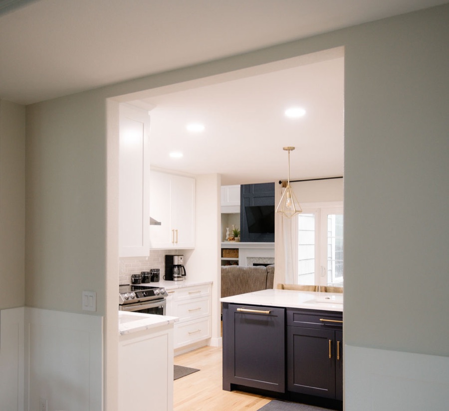 Butler's pass-through with navy base cabinets and white uppers — Stonegate main floor renovation in Parker, Colorado