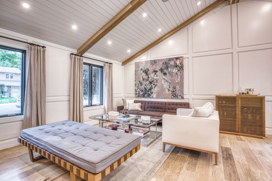 Open great room with kitchen island and dining beneath the beams — Fulton Street whole house renovation in Greenwood Village