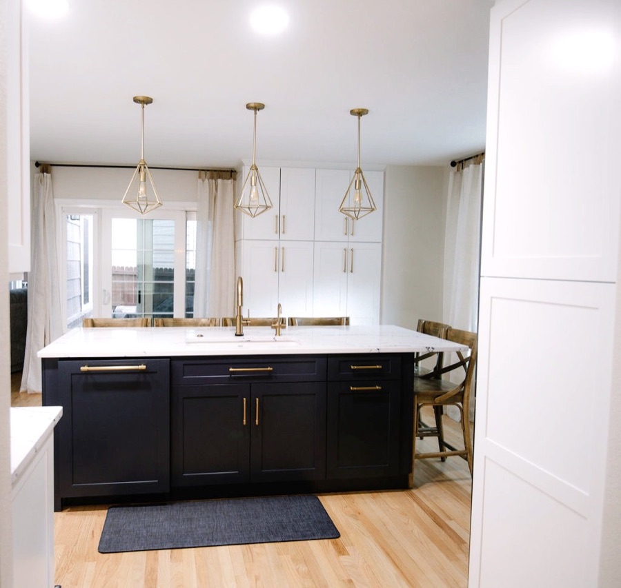 Navy island with brass pulls and white quartz waterfall edges — Stonegate main floor renovation in Parker, Colorado