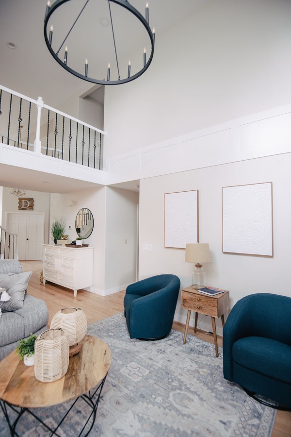 Family room seating area with round wood side tables and soft blue rug — Stonegate main floor renovation in Parker, Colorado