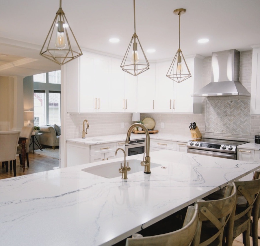 Geometric brass pendants over the marble-look island — Stonegate main floor renovation in Parker, Colorado