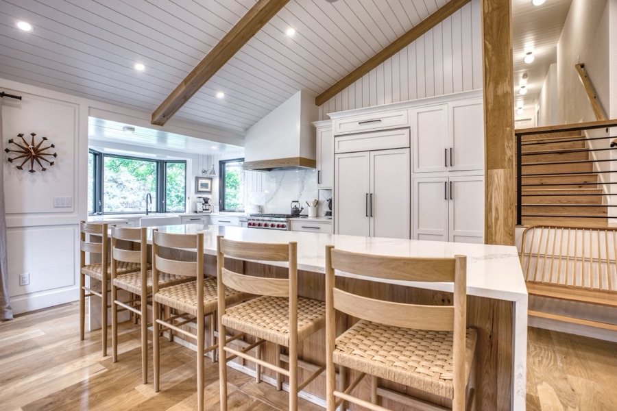 Kitchen island seating with woven barstools beneath the opened ceiling — Fulton Street whole house renovation in Greenwood Village