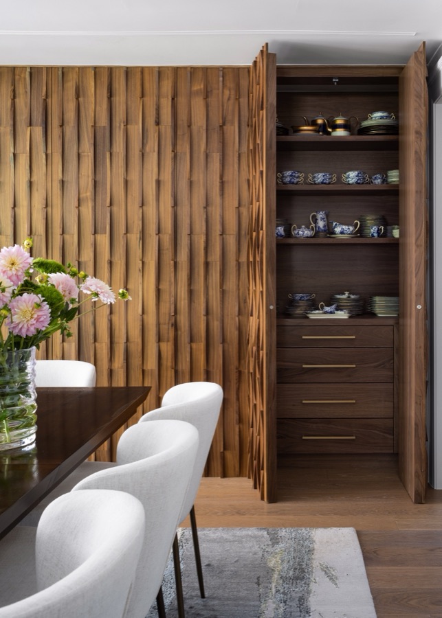 Wood-paneled dining wall opens to reveal hidden china storage — Greenwood Village hidden-detail whole home renovation