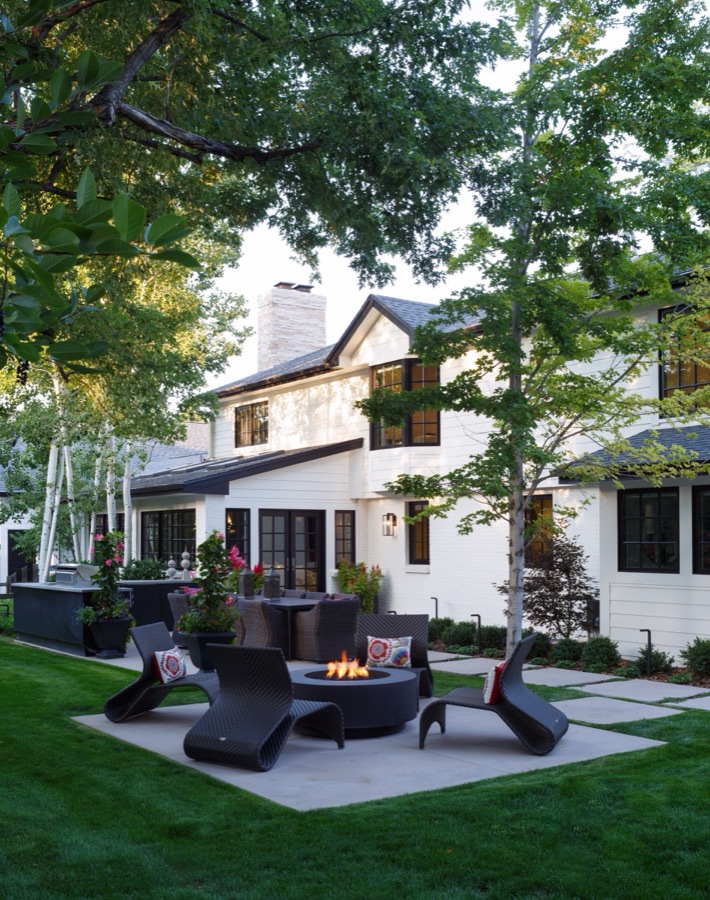White modern-farmhouse exterior with landscaped patio and fire pit seating — Greenwood Village hidden-detail whole home renovation