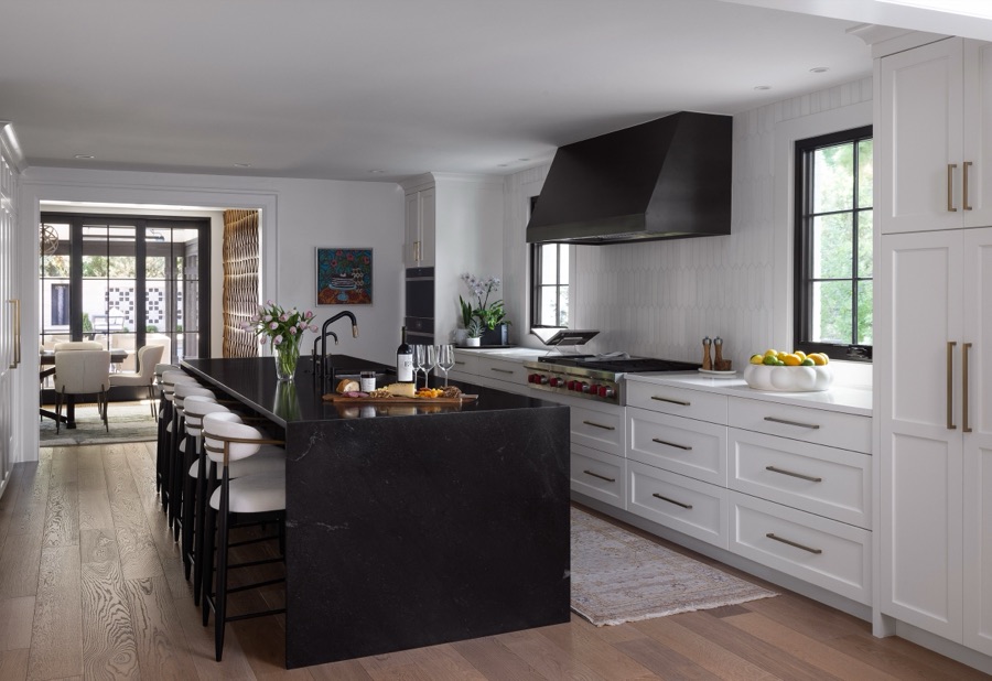 Kitchen with black island, white perimeter cabinetry, and window wall to the backyard — Greenwood Village hidden-detail whole home renovation