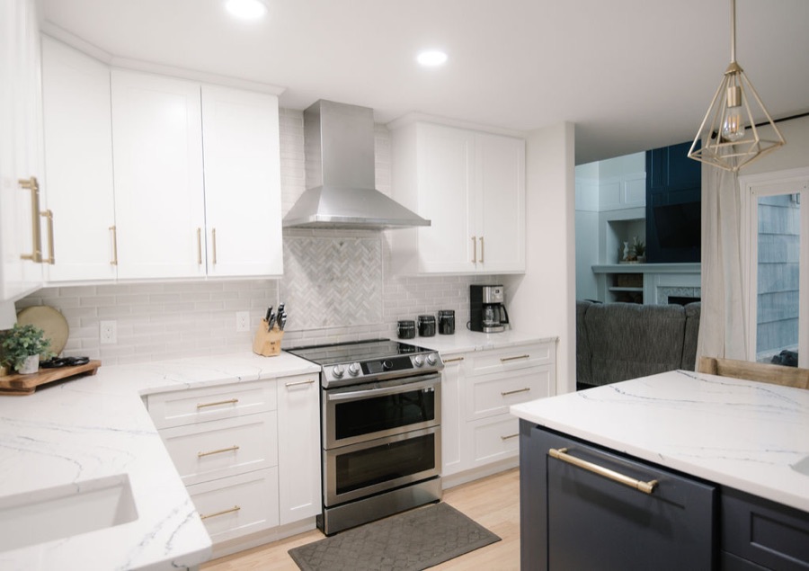 Kitchen with white cabinetry, gold hardware, and stainless range hood — Stonegate main floor renovation in Parker, Colorado