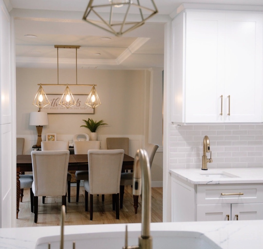 Dining room with upholstered chairs and view into the renovated kitchen — Stonegate main floor renovation in Parker, Colorado
