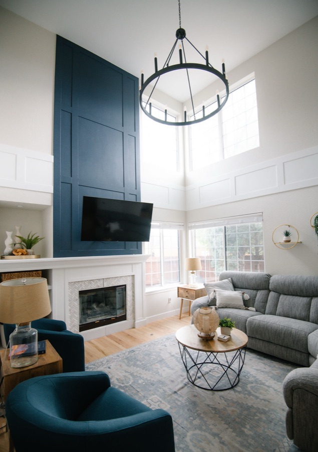 Full-height navy fireplace wall with white mantle in the double-height living room — Stonegate main floor renovation in Parker, Colorado