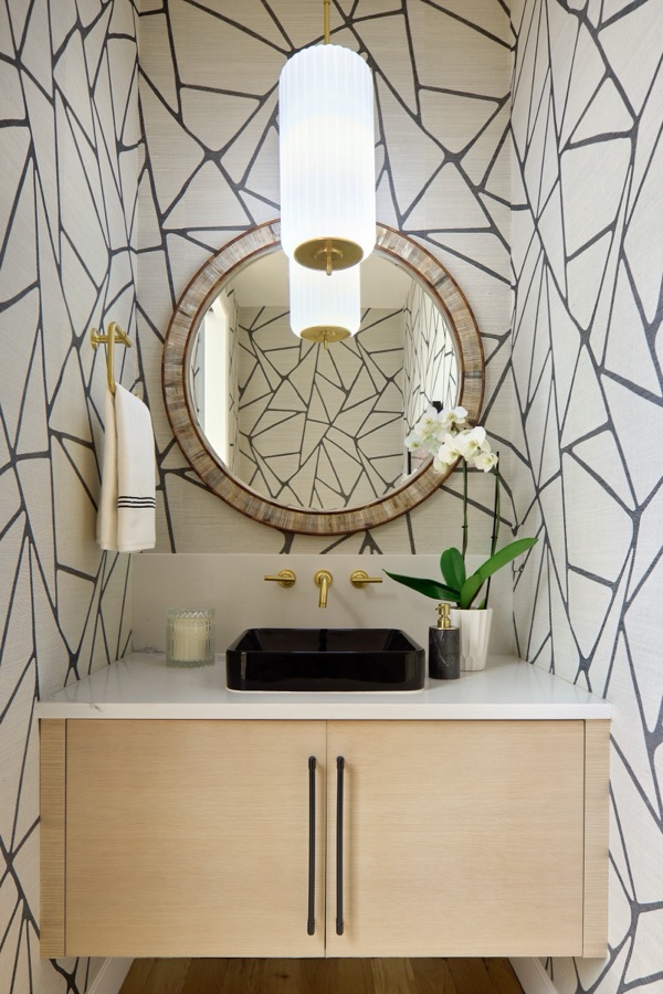 Powder room with geometric marble-look wallpaper, round brass mirror, and white oak floating vanity — Bonnie Brae whole home renovation in Denver