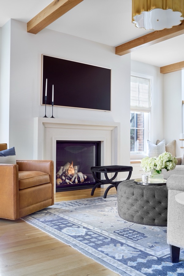 Fireplace sitting area with camel leather armchair and cast-stone surround — Bonnie Brae whole home renovation in Denver