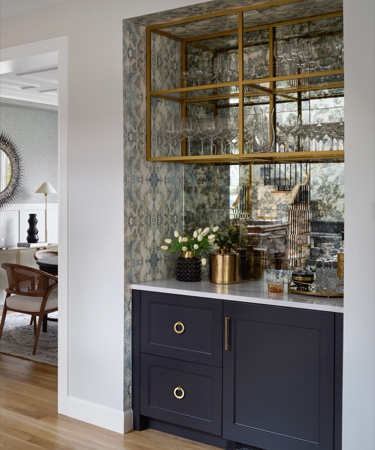 Basement bar with antique mirror backsplash, brass shelving, and navy cabinetry — Bonnie Brae whole home renovation in Denver