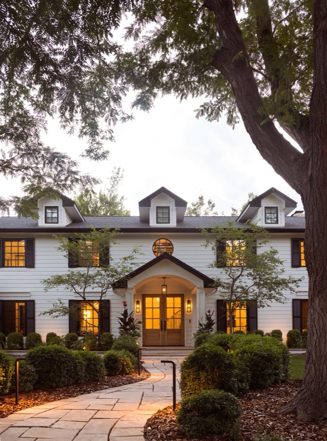 Front elevation at twilight framed by mature trees — Greenwood Village hidden-detail whole home renovation