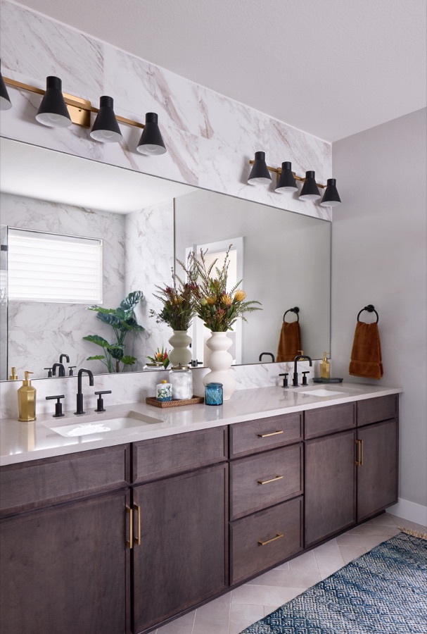 Primary bath vanity with dark wood cabinetry and black fixtures — The Canyons semi-custom new build in Castle Pines
